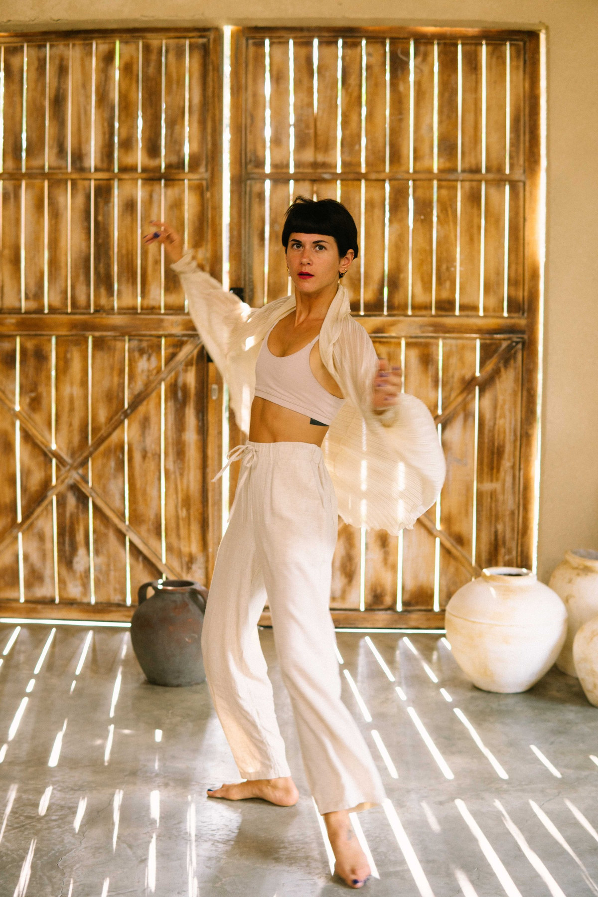 Aalia dancing in white in a bamboo studio