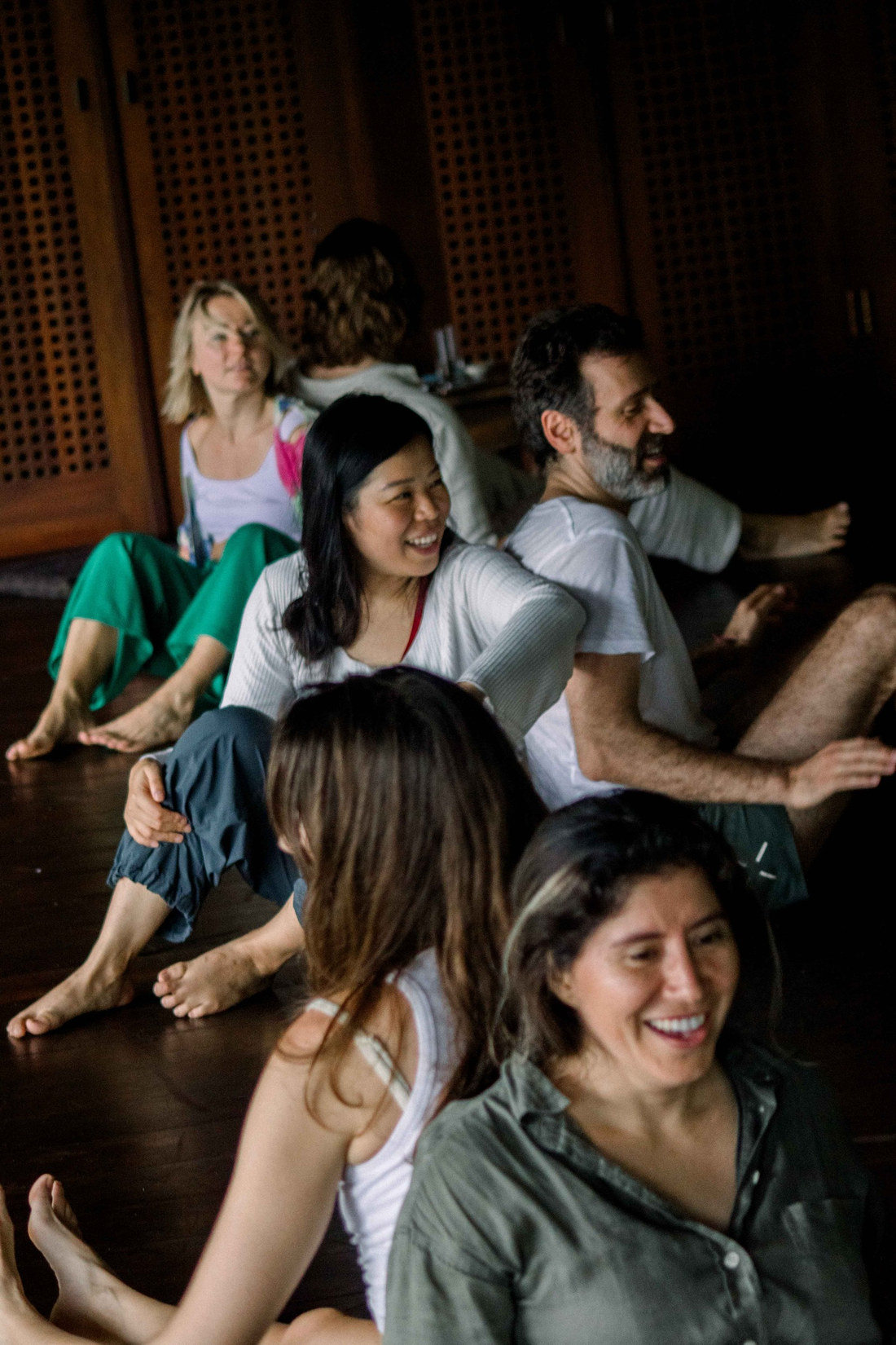 Dancers laughing together in a dark studio