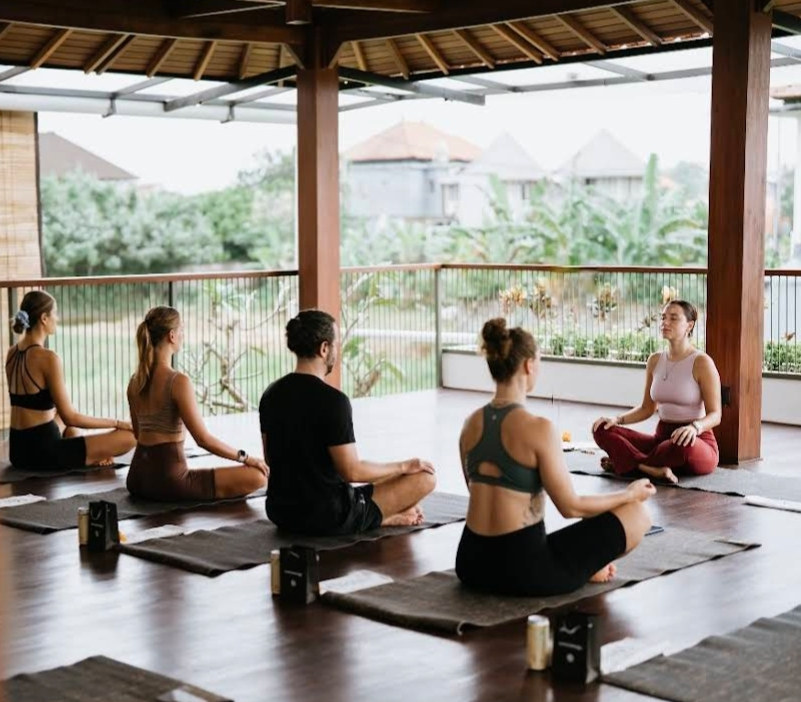 A group seated in meditation on mats in the Rasa Yoga studio