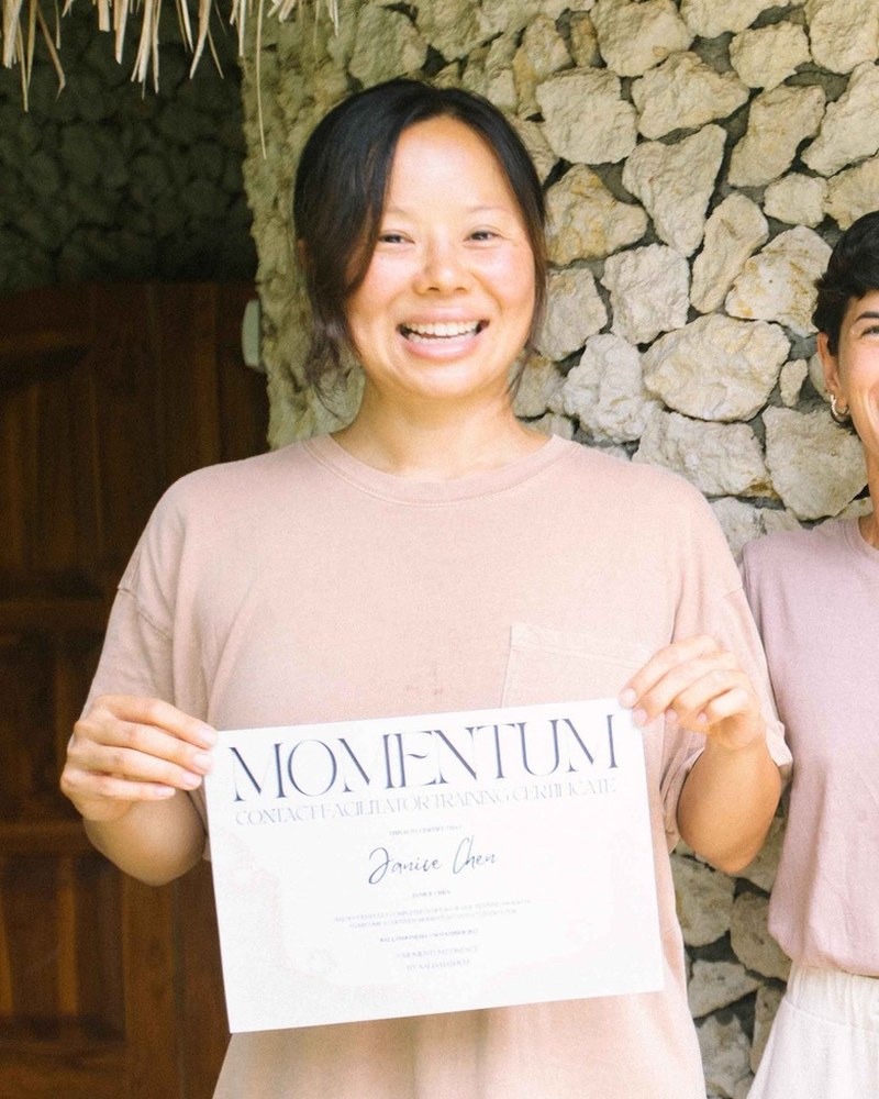 Janice smiling and holding her Momentum certificate