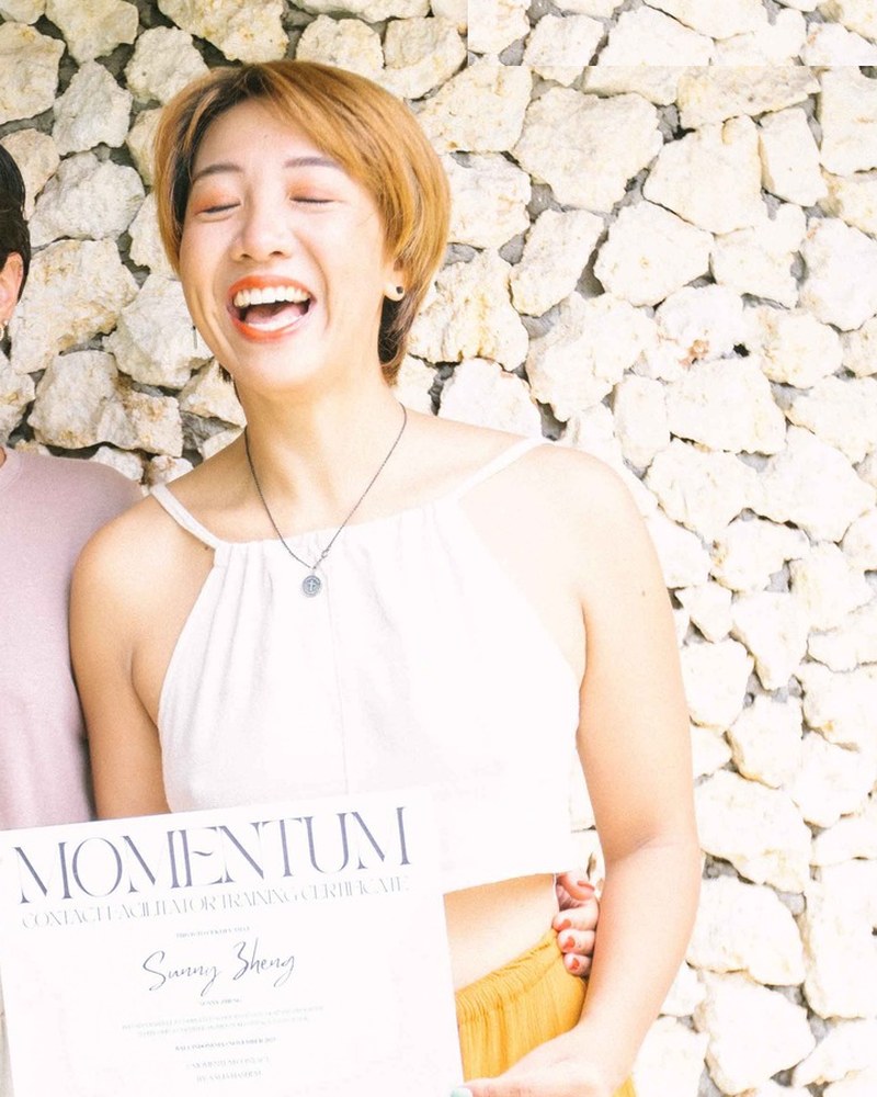 Sunny Zheng laughing and holding her Momentum certificate